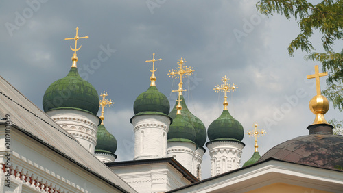 Photography White church towers topped with green onion domes ornate golden crosses against moody gray clouds