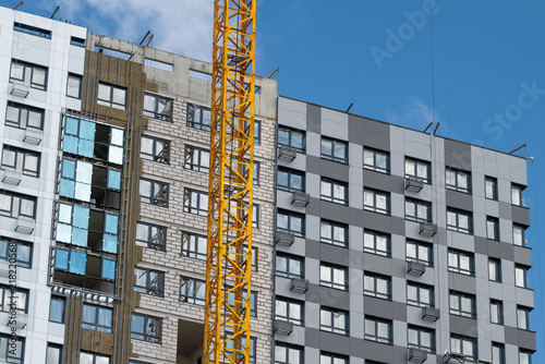 Modern buildings rise against the blue sky amidst construction work in a vibrant urban area