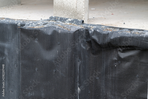 Photography Construction site features a textured black barrier securing the foundation of a