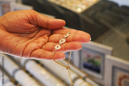 Hand holding jewelry in a shop display