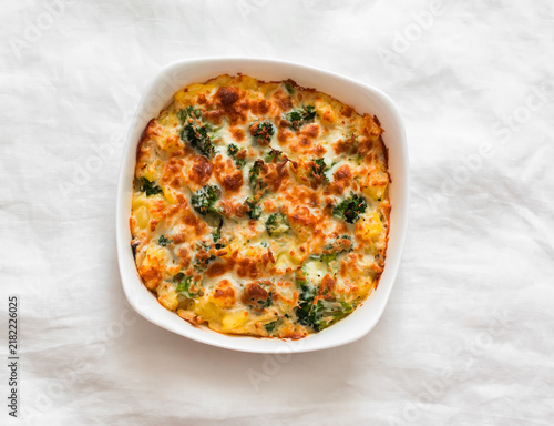 Baked frittata with broccoli, potatoes and chicken in a baking dish - a delicious breakfast, snack, tapas on a light background, top view