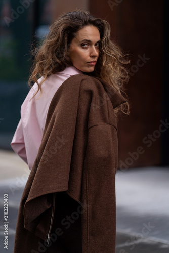 Young woman looking back over shoulder with jacket in the city