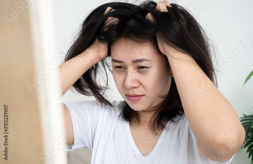 Canvastavla Stressed Asian woman with messy hair looking in mirror, suffering from insomnia, sleepless night, fatigue, scalp itchiness, and hair loss