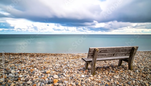 Wooden bench on quiet pebble beach by sea