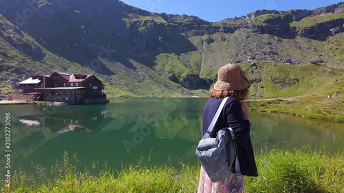 Woman traveler enjoying the view across Balea Lake in the Carpathian Mountains of Romania