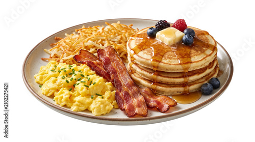Traditional American breakfast platter with pancakes, crispy bacon and scrambled eggs. Hearty morning meal with hash browns and maple syrup.