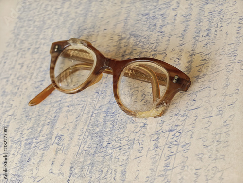 vintage tortoiseshell eyeglasses on underlying handwritten document written in a unintelligible cursive script creates a timeless, academic aesthetic