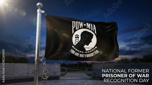 Pow mia flag waving against a dark blue evening sky for national former prisoner of war recognition day