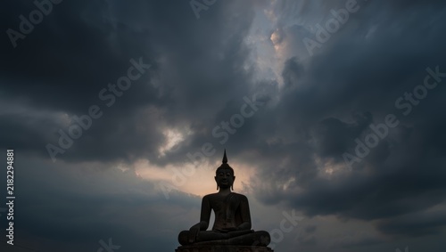 Buddha Statue Silhouette Against Stormy Sky