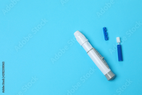 Blood glucose meter with lancets, top view. Medical device and diabetes concept.