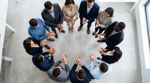 Diverse business team standing in circle view from above, joining hands together in unity, teamwork, collaboration, partnership, success celebration, corporate group huddle