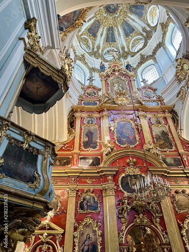 Принти на полотні Ornate Baroque interior of a historic church in Kyiv, Ukraine, featuring a richly decorated red and gold iconostasis, religious paintings, gilded architectural details and an elaborate domed ceiling