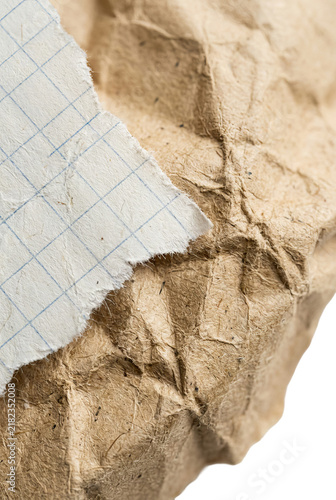 Close-up of Torn Graph Paper on Crumpled Brown Paper.