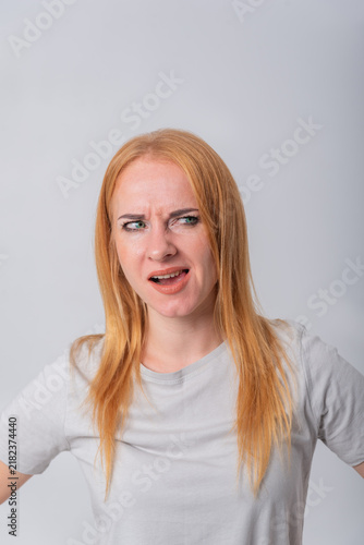 Konstfotografi Young redhead woman showing skepticism and uncertainty, scrunching her nose and