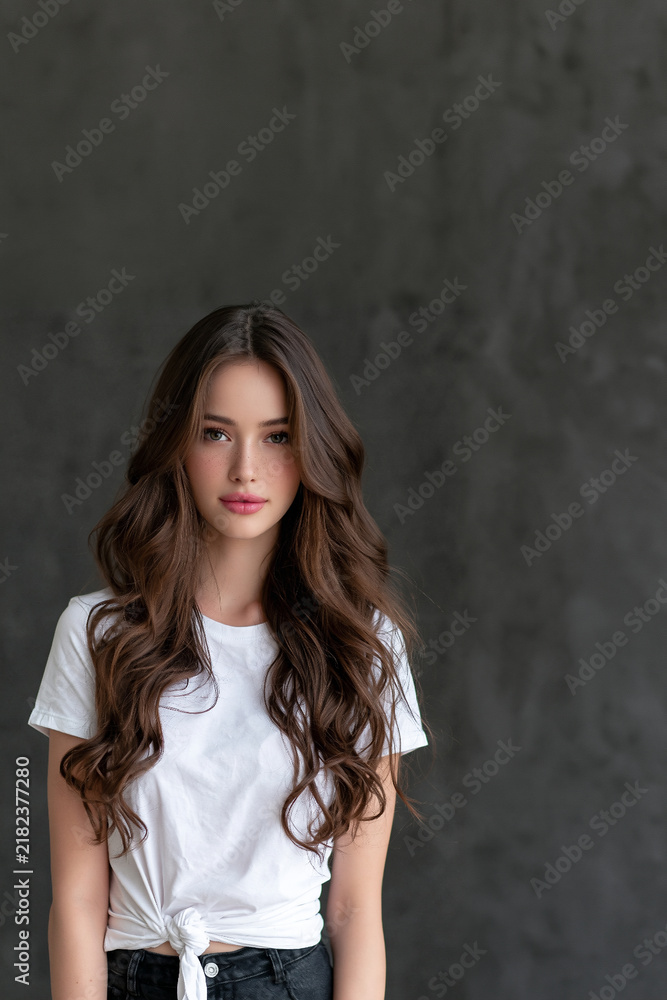 Fototapeta premium cute attractive woman waving in an isolated portrait, beautiful girlfriend smiling and waving against isolated background, charming young woman posing with a friendly wave 