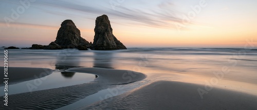 The Twin Rock Formations at Sunset Over a Tranquil Seashore