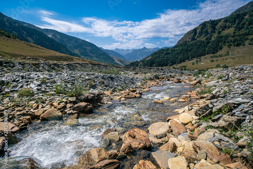 Senderismo por las montañas y valles del Valle de Aran en el Pririneo, caminando junto a un río alpino