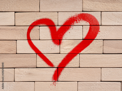 Obraz na płótnie Red heart spray painted on wooden brick wall symbolizing love, romance and romantic relationship