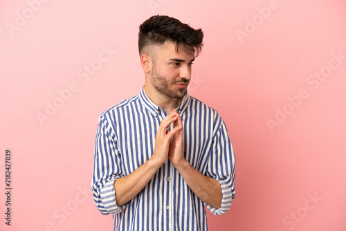 Foto Young caucasian man isolated on pink background scheming something