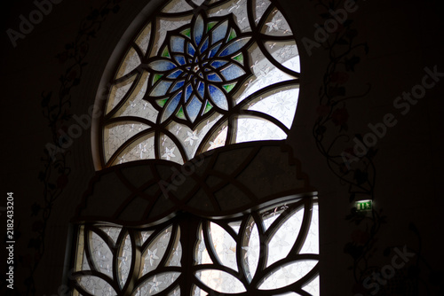 Stained glass detail on the beautiful Grand Mosque building in Abu Dhabi with beautiful flower shape patterns and geometric textures