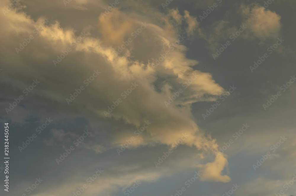 Obraz premium Scenic landscape photography of a dynamic sunlit cloud formation against a moody twilight sky
