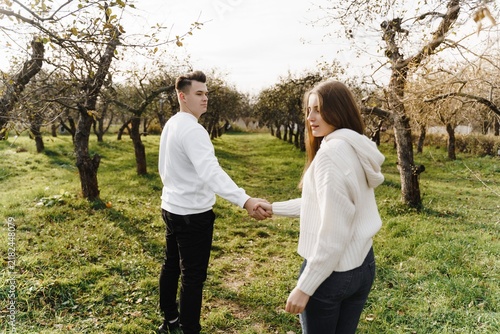 Photography Young couple holding hands in an autumn orchard, during a tender