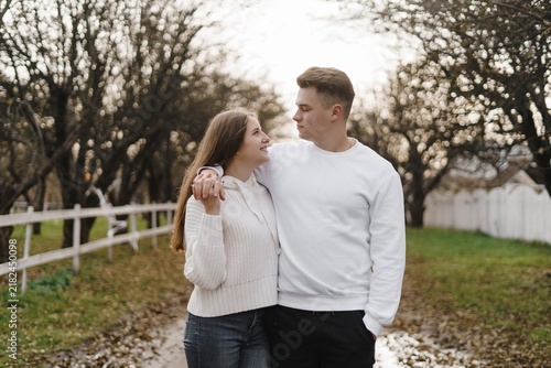 Foto Couple embracing beside a park fence, in a peaceful park setting
