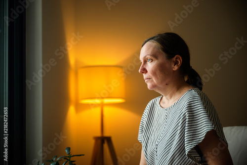 Cuadro en lienzo Mature woman reflecting quietly while sitting on a sofa at home