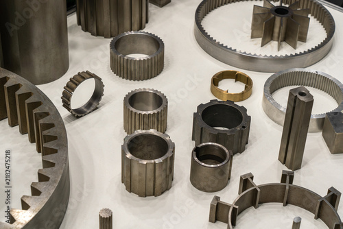 Precision machined metal gears, drive couplings, splined sleeves, and custom steel components displayed on white table