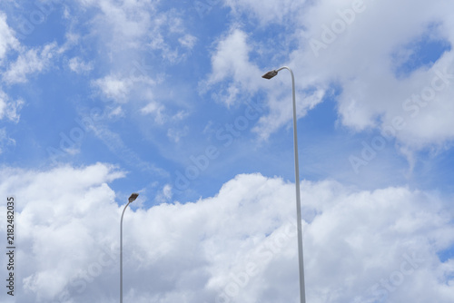 Street Lights Against Blue Sky and White Clouds