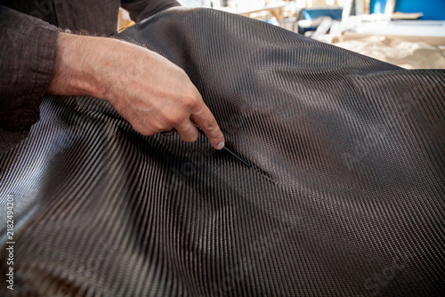 Hands smooth out creases in carbon fiber with a squeegee