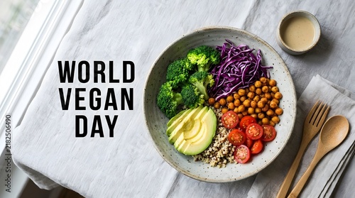 A top down view of a healthy vegan buddha bowl with fresh vegetables and chickpeas served on a white textured table background
