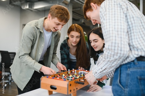 Fotografie Startup employees playing table football during a break