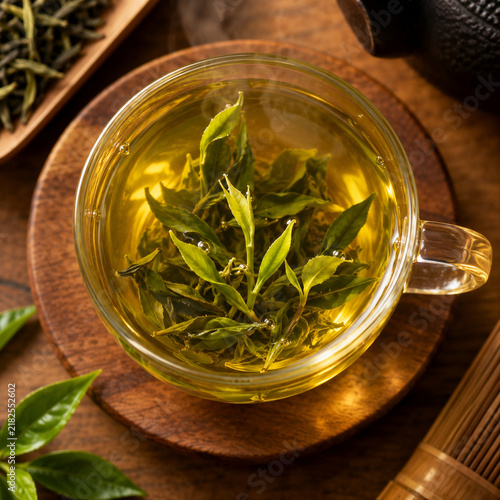Fresh Green Tea Infusion in Glass Cup with Whole Leaves Top View