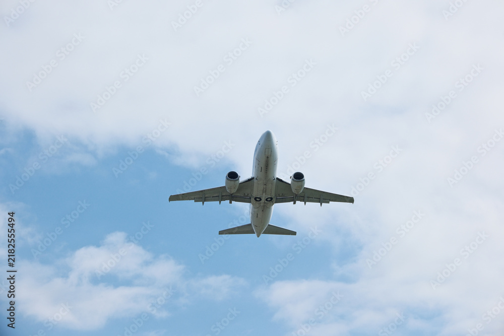 Fototapeta premium Commercial Passenger Airplane Climbing High After Takeoff Against Blue Sky