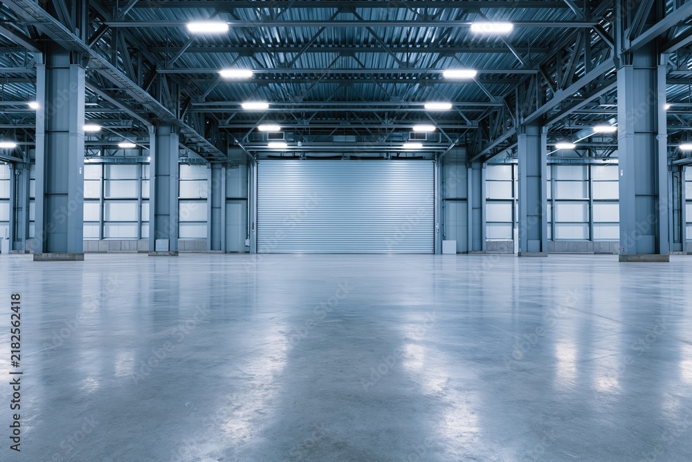 Obraz premium The Empty Industrial Warehouse Interior Bathed in Bright Overhead Lighting