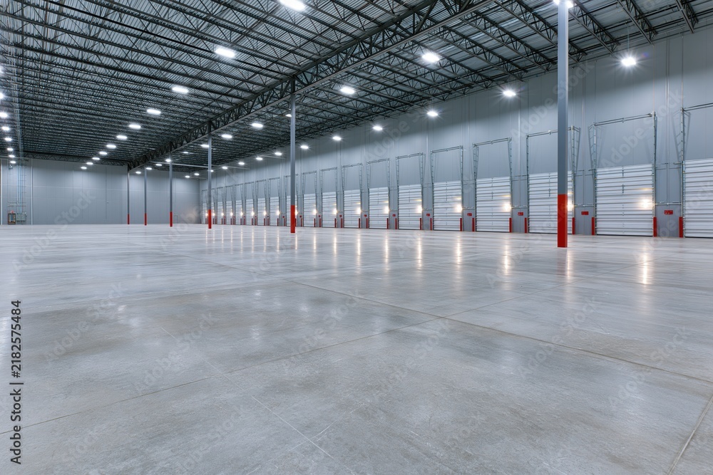 Obraz premium The Empty Warehouse Interior with Bright Industrial Lighting and Long Loading Docks