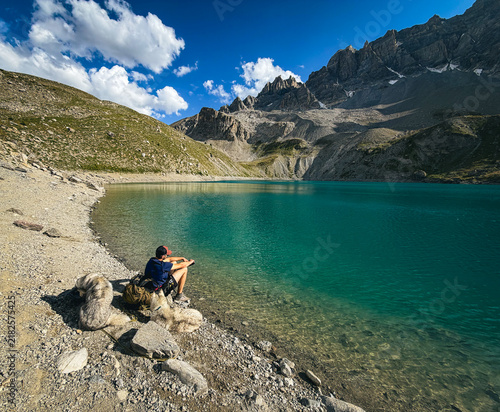Photography Hiker and two dogs enjoying Lac Sainte-Anne surrounded by alpine mountains