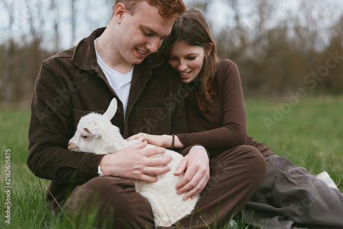 Fotografie Goat kid outdoors couple lifestyle tender moment sunlit meadow gentle touch rela