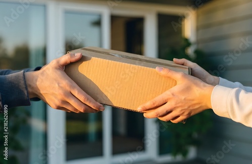 Delivery Person Handing Over Package in Front of House