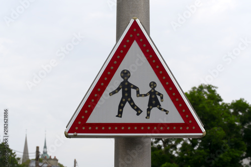 Fotografía Close-up of traffic sign beware of school children crossing at French city of Bayeux on a summer day