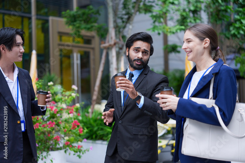 Quadro su tela An Asian businessman, an Indian businessman and a European businesswoman walk th