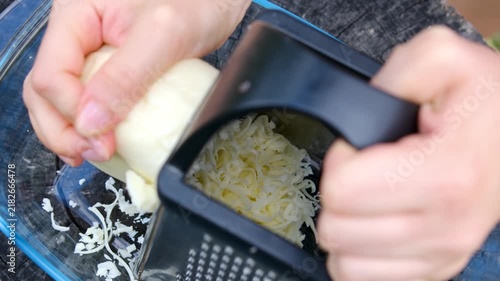 Homemade countryside cooking begins with cheese freshly grated and spread over a tortilla with ripe garden tomatoes before the rustic snack is grilled outdoors over charcoal. Close up.