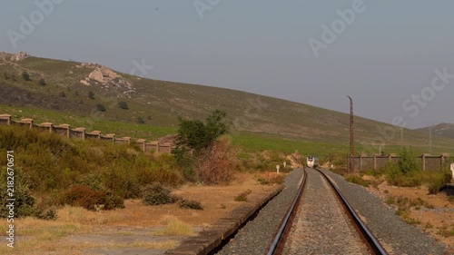 White Train Approaching Along Remote Mountain Railway Line