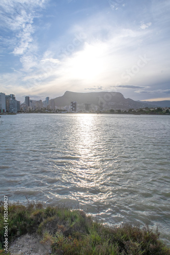 Obraz na plátně Calpe cityscape reflecting sunlight on water