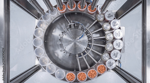 Circular indexing table fills cat treat tubs in a factory setting