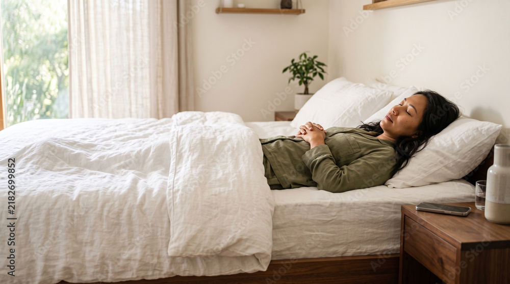 Fototapeta premium Asian woman sleeping peacefully on comfortable bed at home