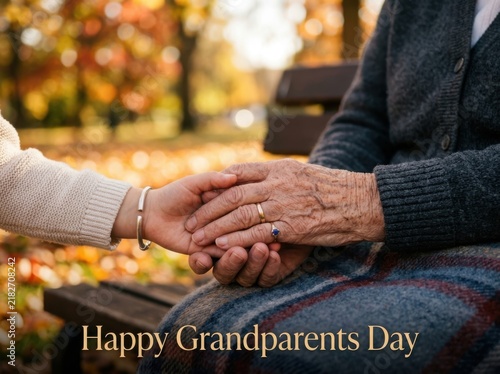 Closeup of a young person holding the wrinkled hands of an elderly person outdoors in autumn, celebrating grandparents day