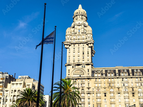 Palacio Salvo em Montevidéu, Uruguai, com bandeira uruguaia e palmeiras