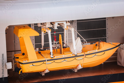 Quadro su tela Yellow Rescue Boat Suspended on Launching Davits Onboard a Cruise Ship Deck